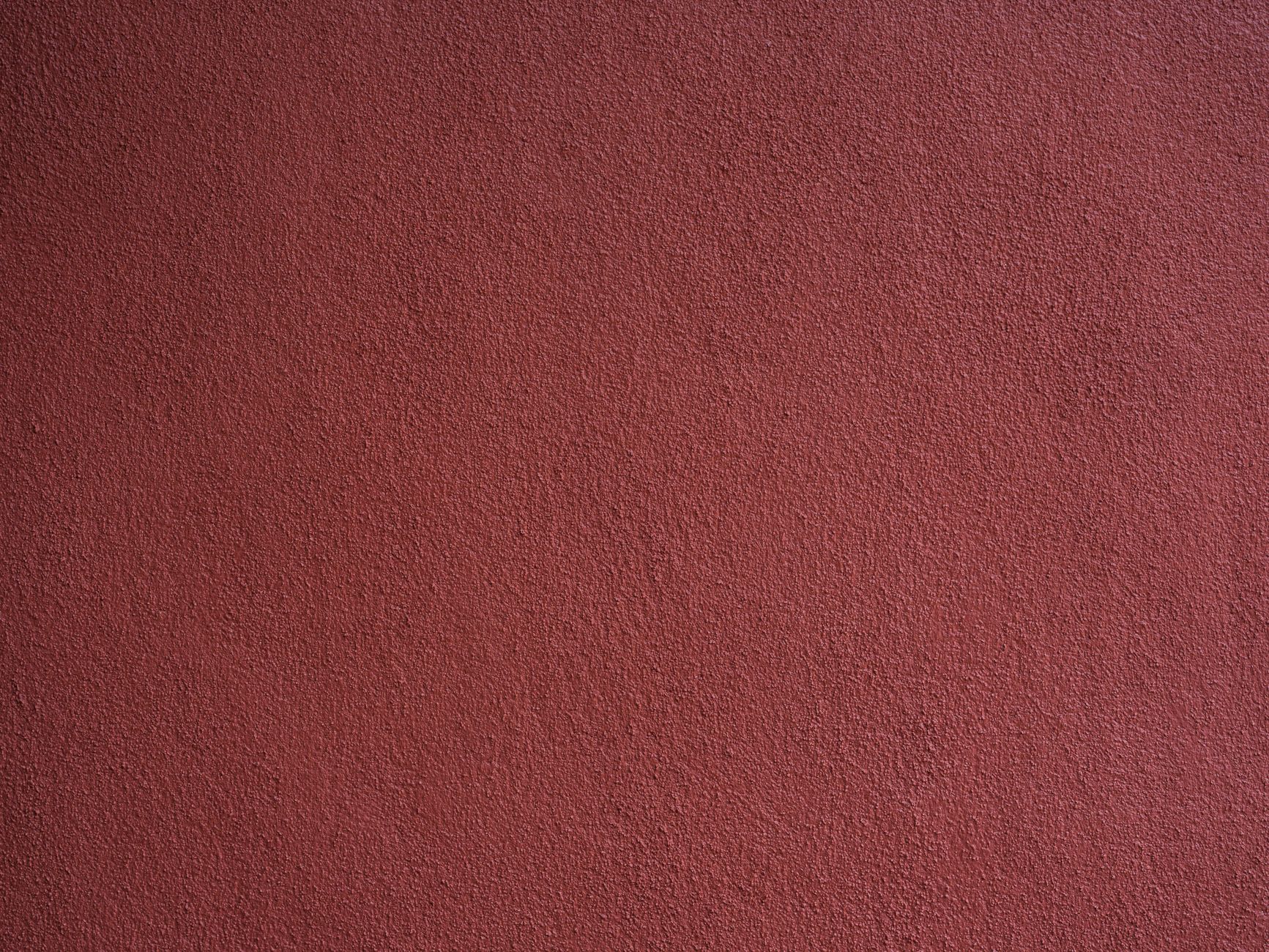 Detailed close-up view of a red textured wall perfect for backgrounds or design use.