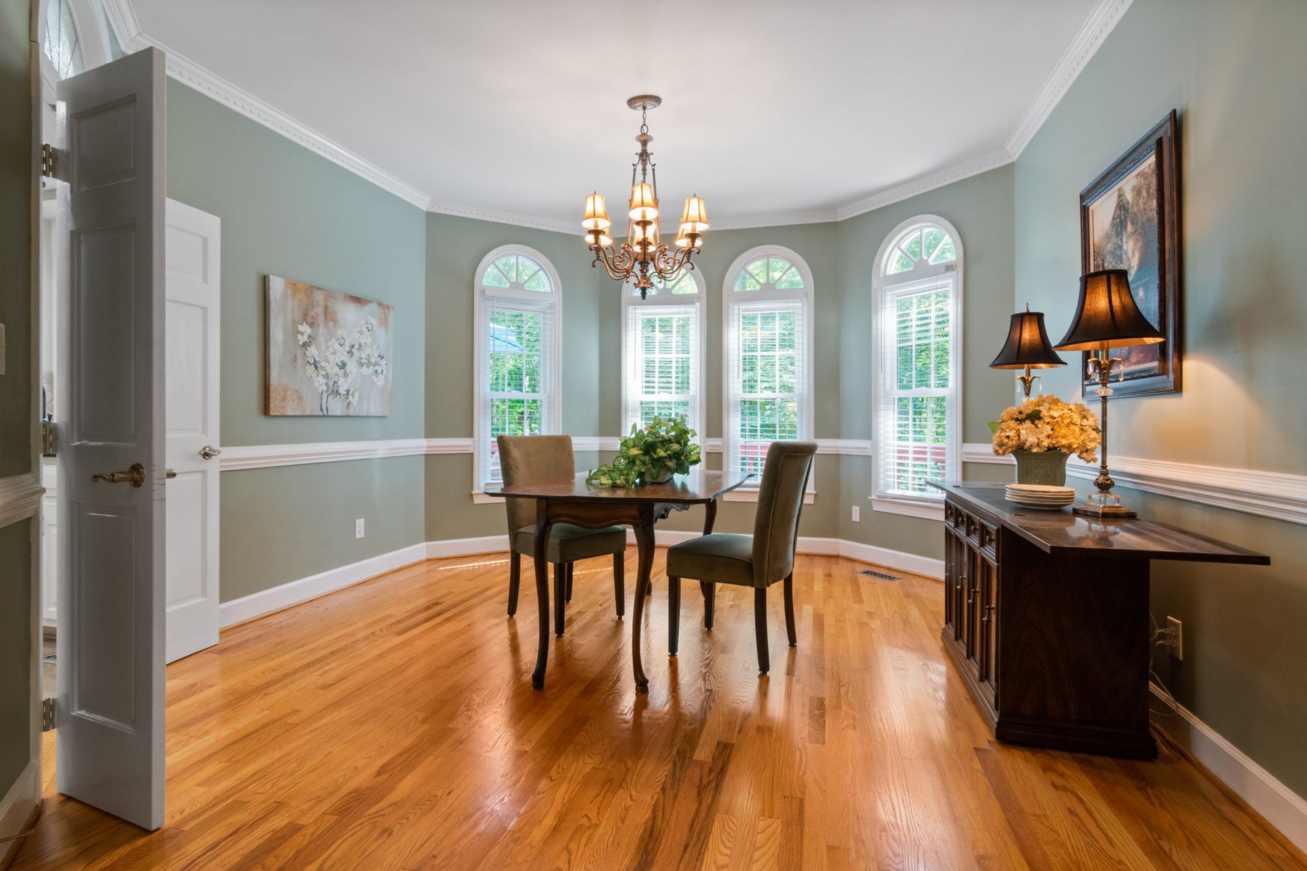 A beautifully decorated dining room with classic style furniture and a chandelier.