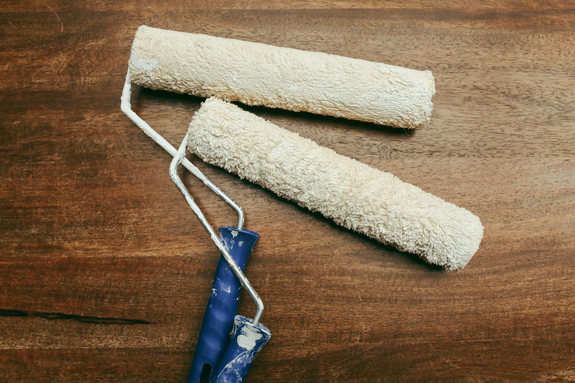 Two paint rollers over a wooden surface, perfect for home renovation concepts.