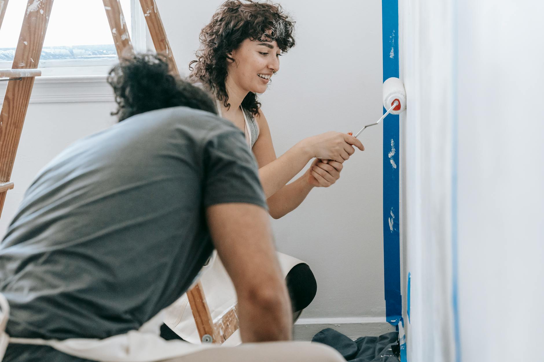 Happy couple painting their new apartment with smiles and enthusiasm.