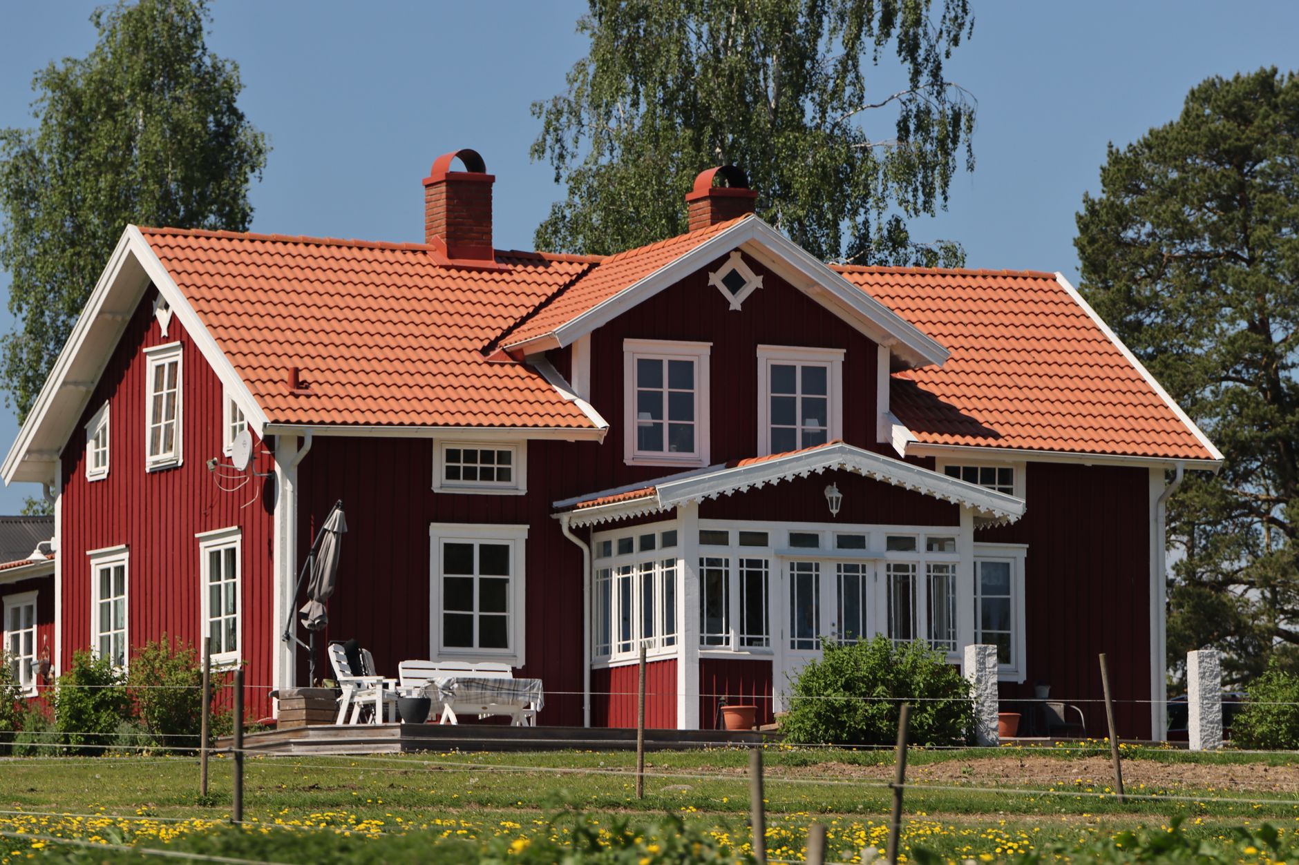 Charming Swedish house with orange roof in a lush green setting, Jönköping, Sweden.