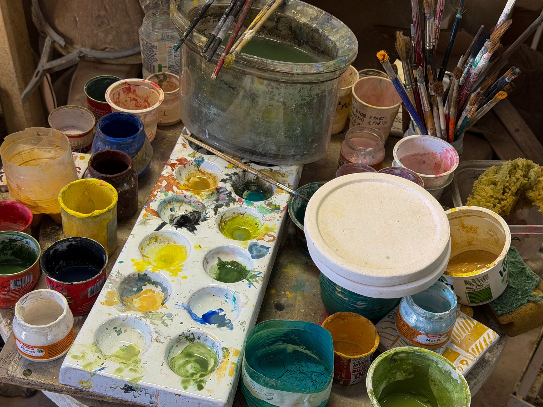A vibrant display of paints and brushes on an artist's workspace, showcasing creativity.