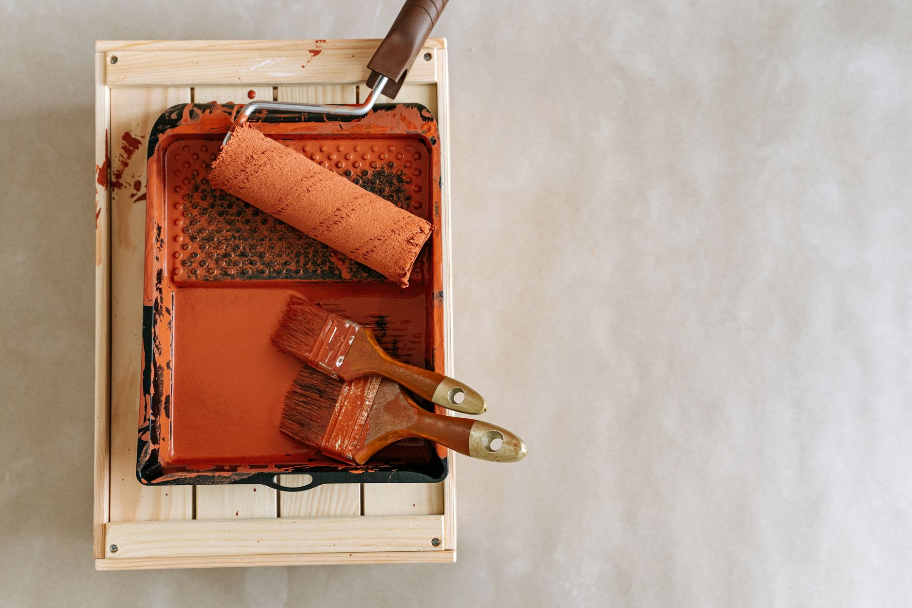An overhead shot of paintbrushes and a roller in a tray, perfect for home renovation projects.