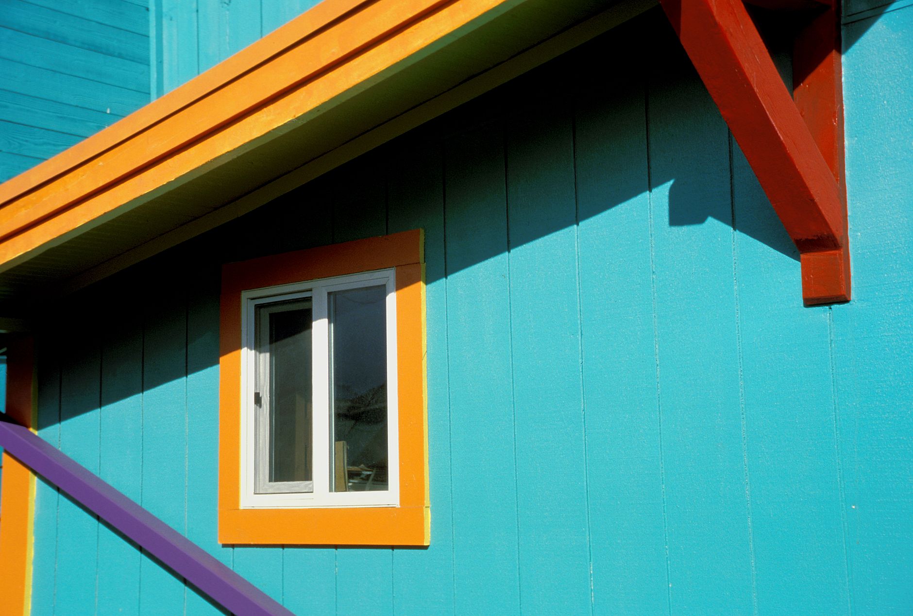 Bright blue, yellow, and orange window frame on a house in Garibaldi, Oregon.