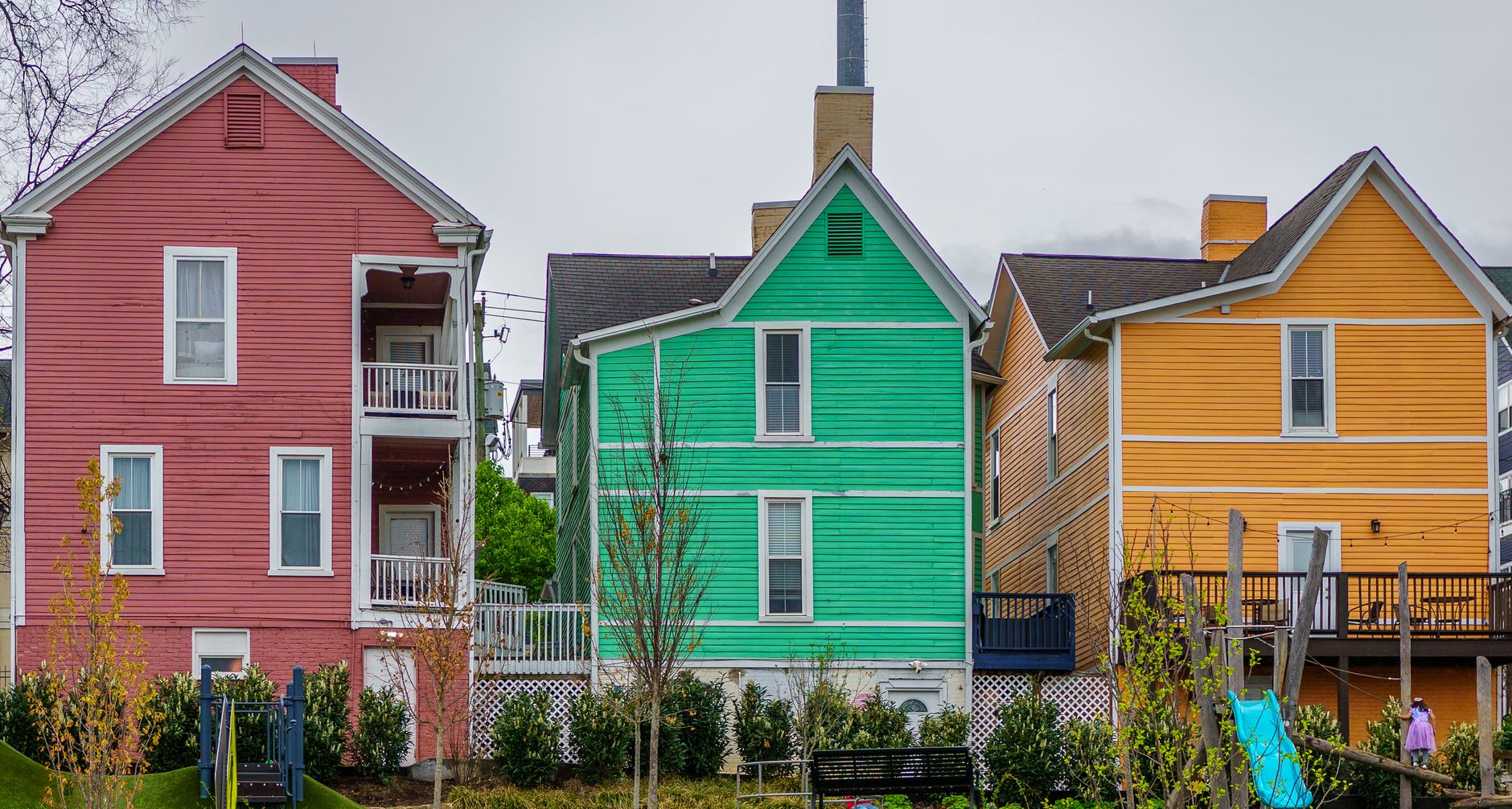 Brightly colored houses in Knoxville, Tennessee neighborhood on a cloudy day.