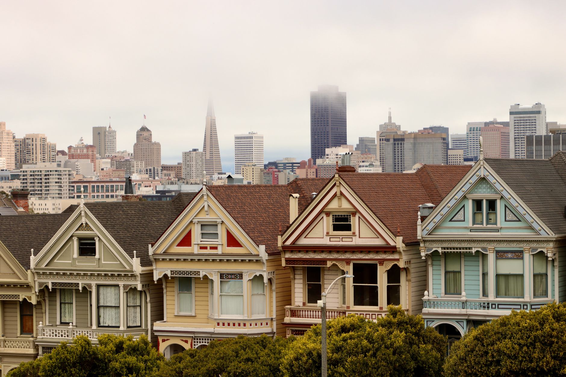Iconic Painted Ladies in San Francisco with city skyline and fog.
