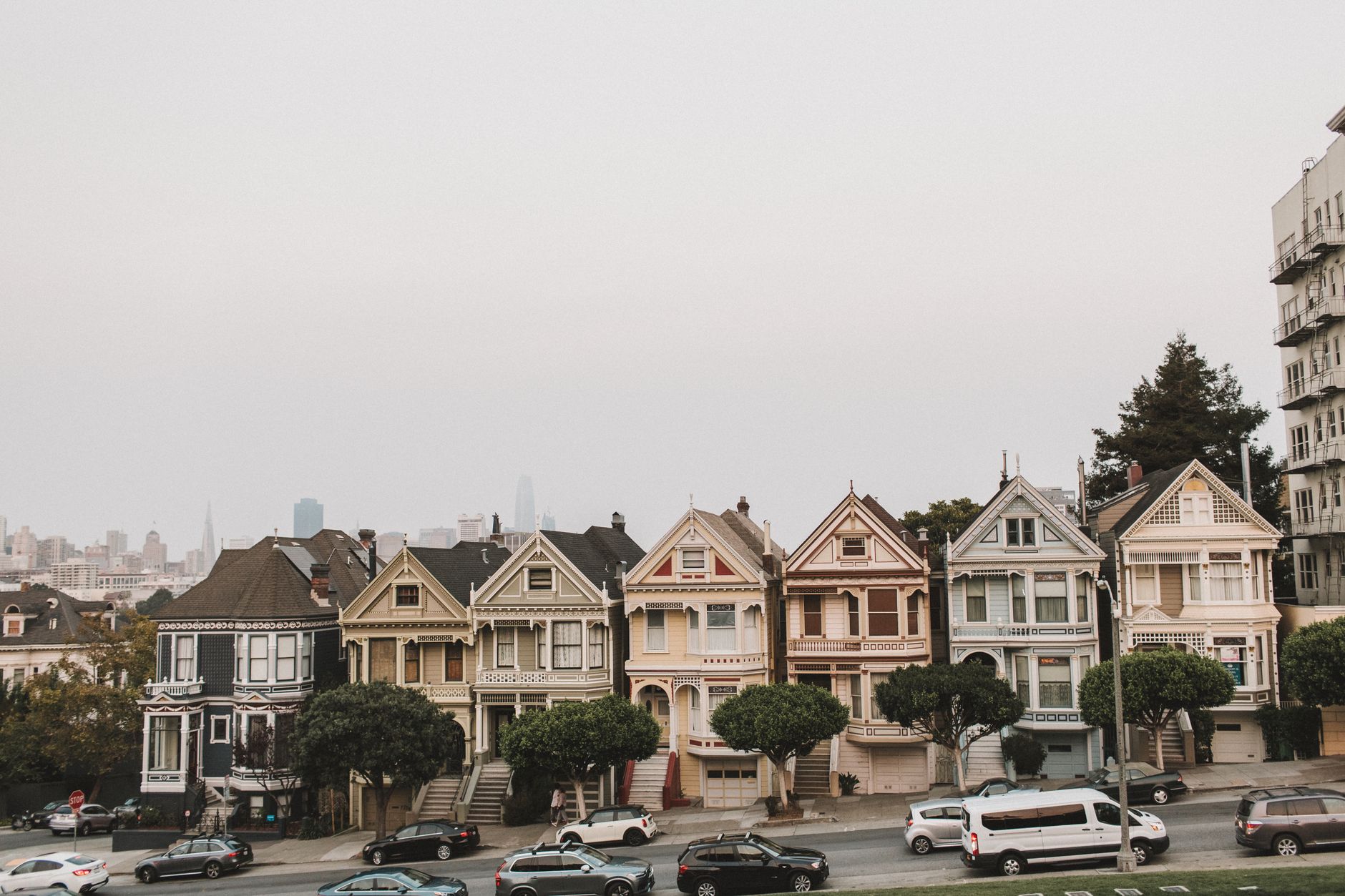 View of San Francisco's famous Painted Ladies with city skyline backdrop, showcasing vibrant architecture.