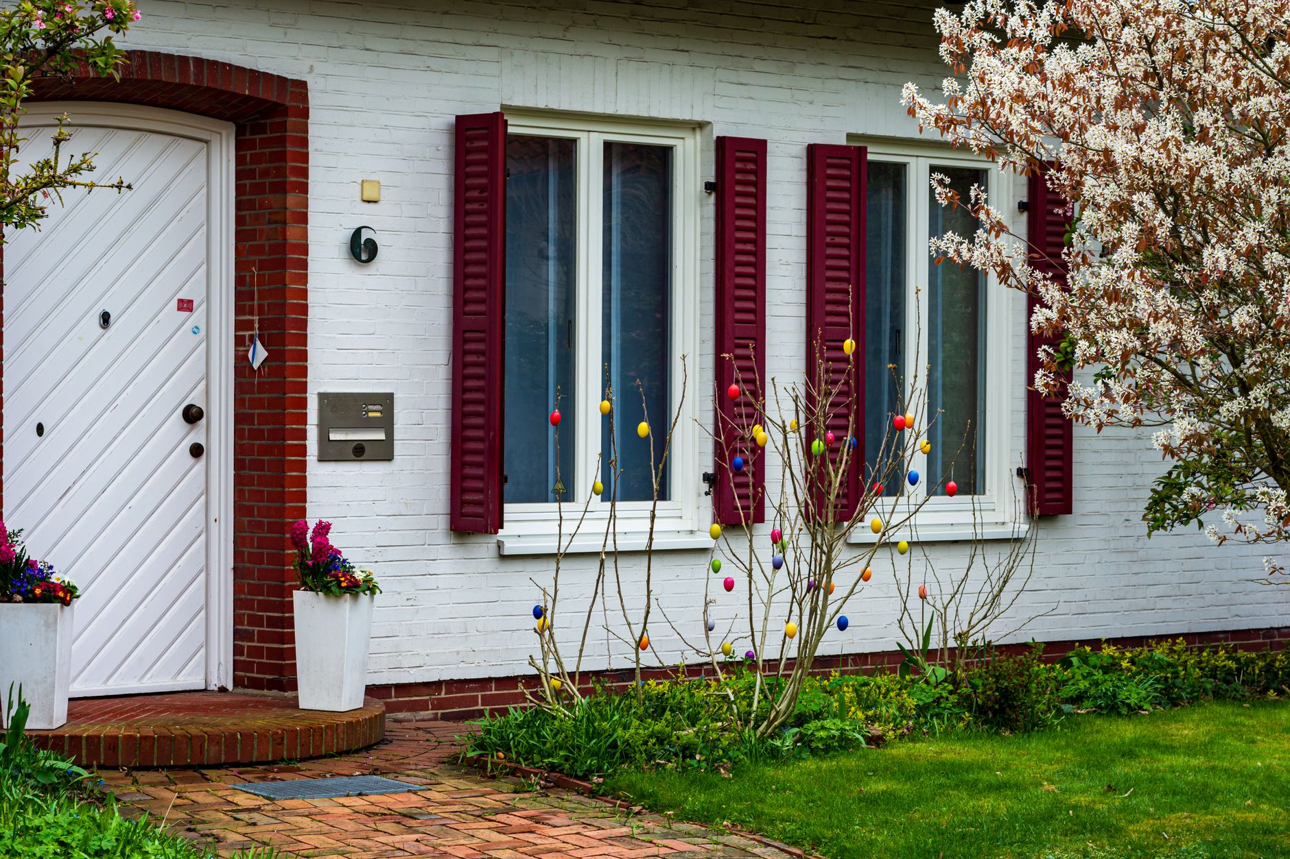 Charming front porch of a German house decorated with colorful Easter eggs.