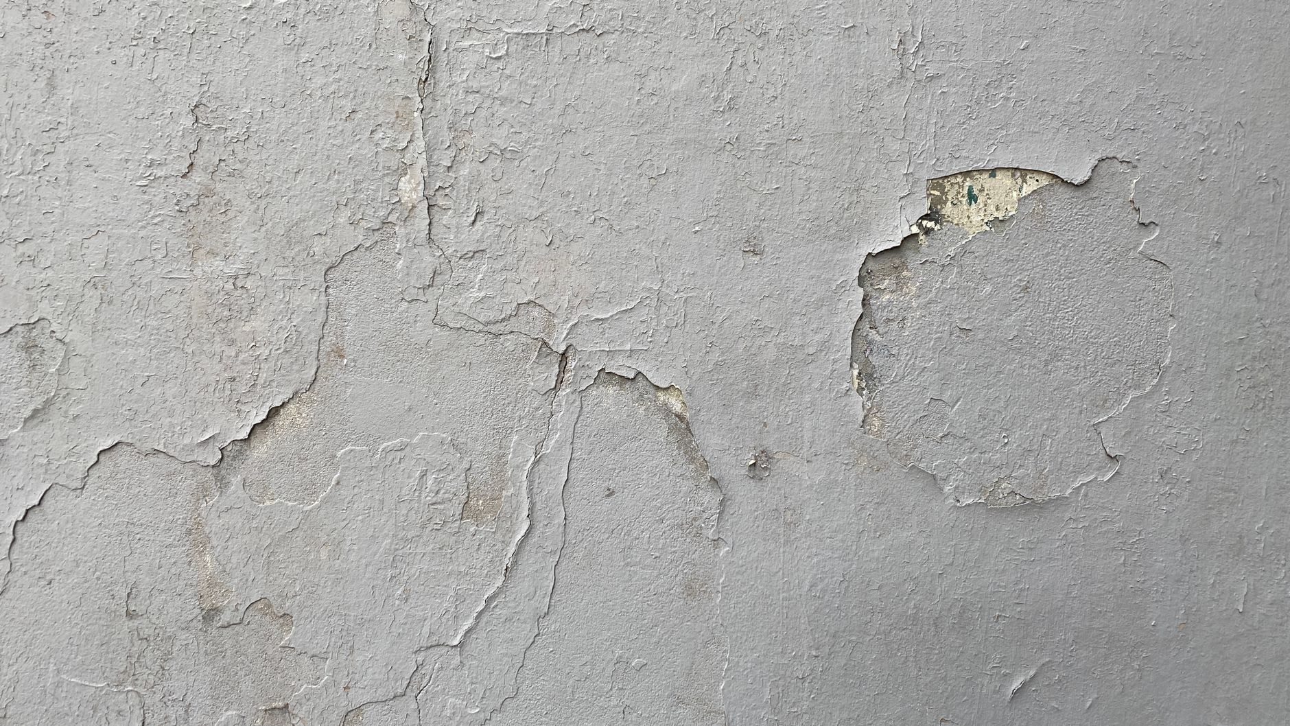 Detailed texture of a weathered wall with peeling paint and cracks, perfect for backgrounds.