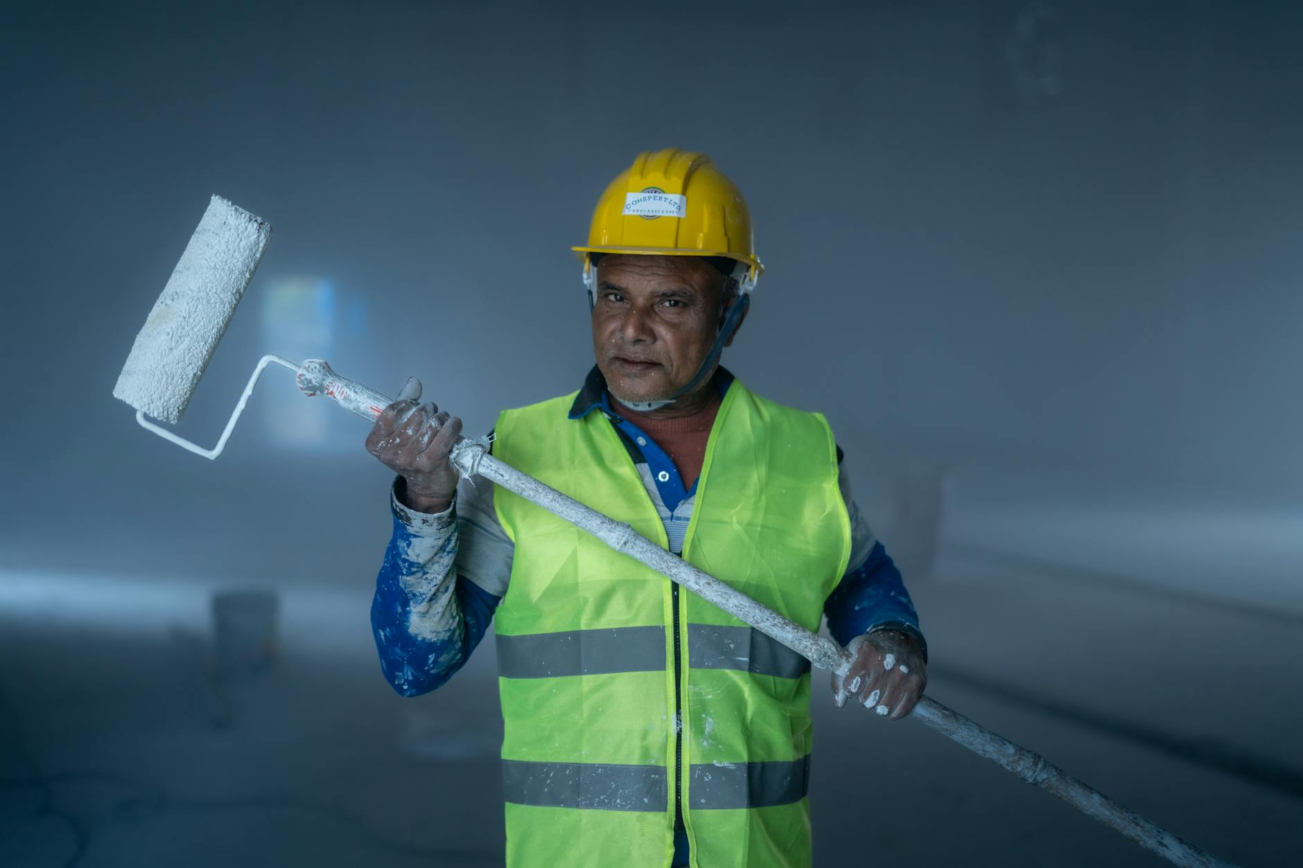 Professional painter applying paint on commercial wall interior, Glass Bay, Newark CA