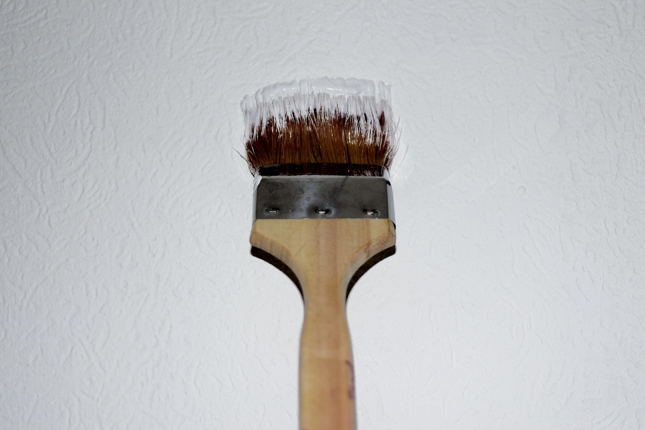 Professional painter sanding a wall during preparation for painting