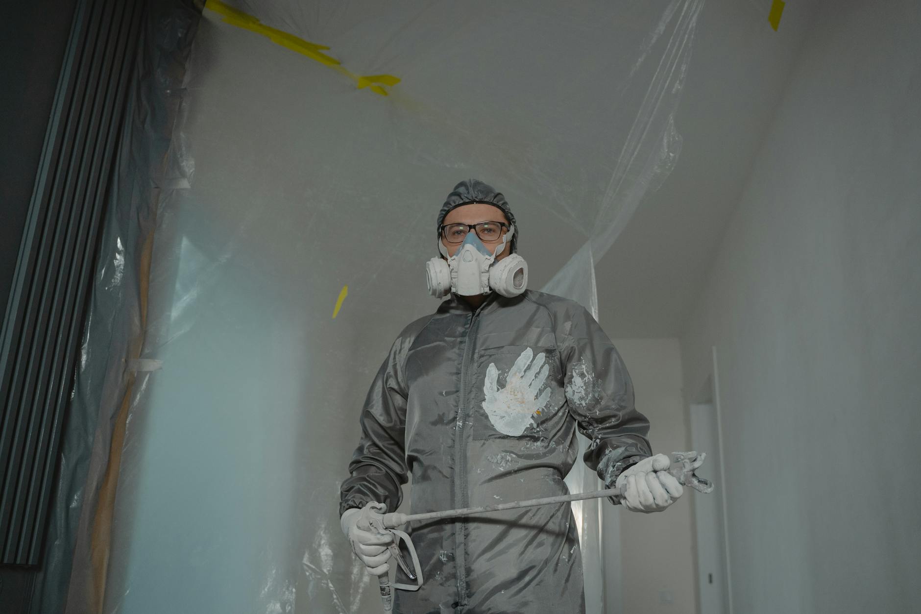 Professional painter preparing a house exterior in a residential neighborhood