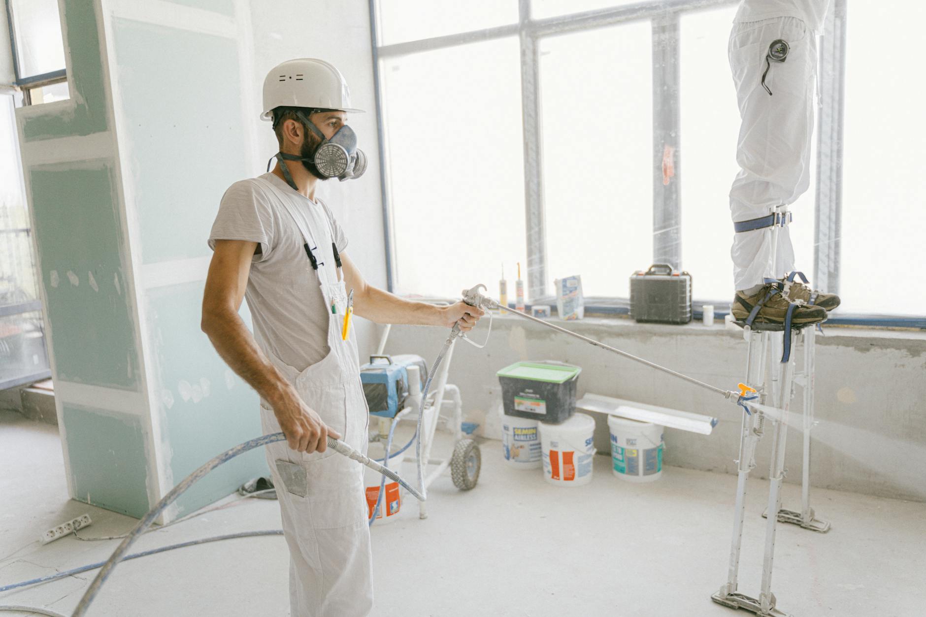 Pintor aplicando calafetação no caixilho da janela