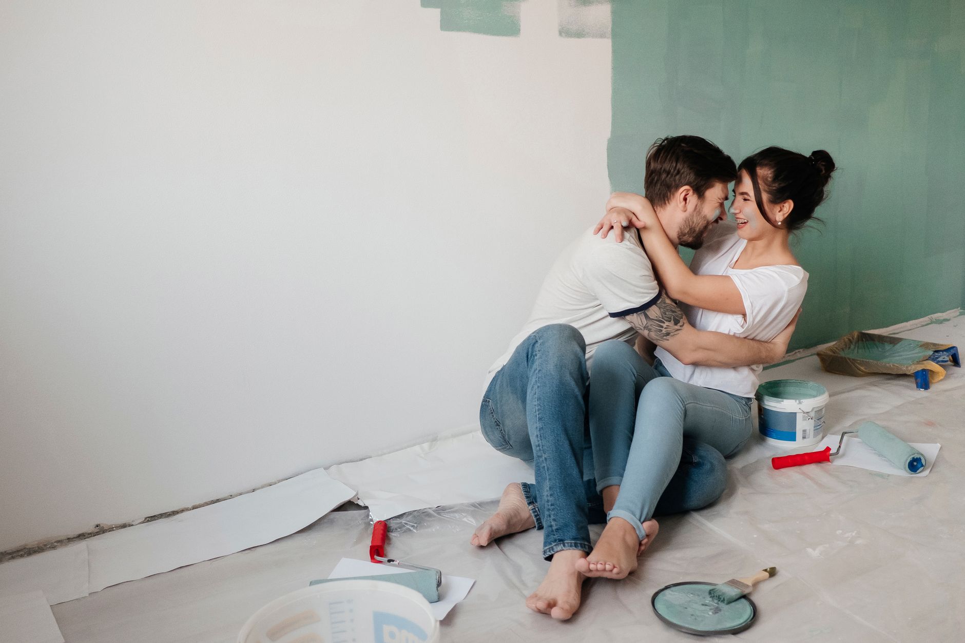 A happy couple embracing while painting their new home, creating cherished memories.